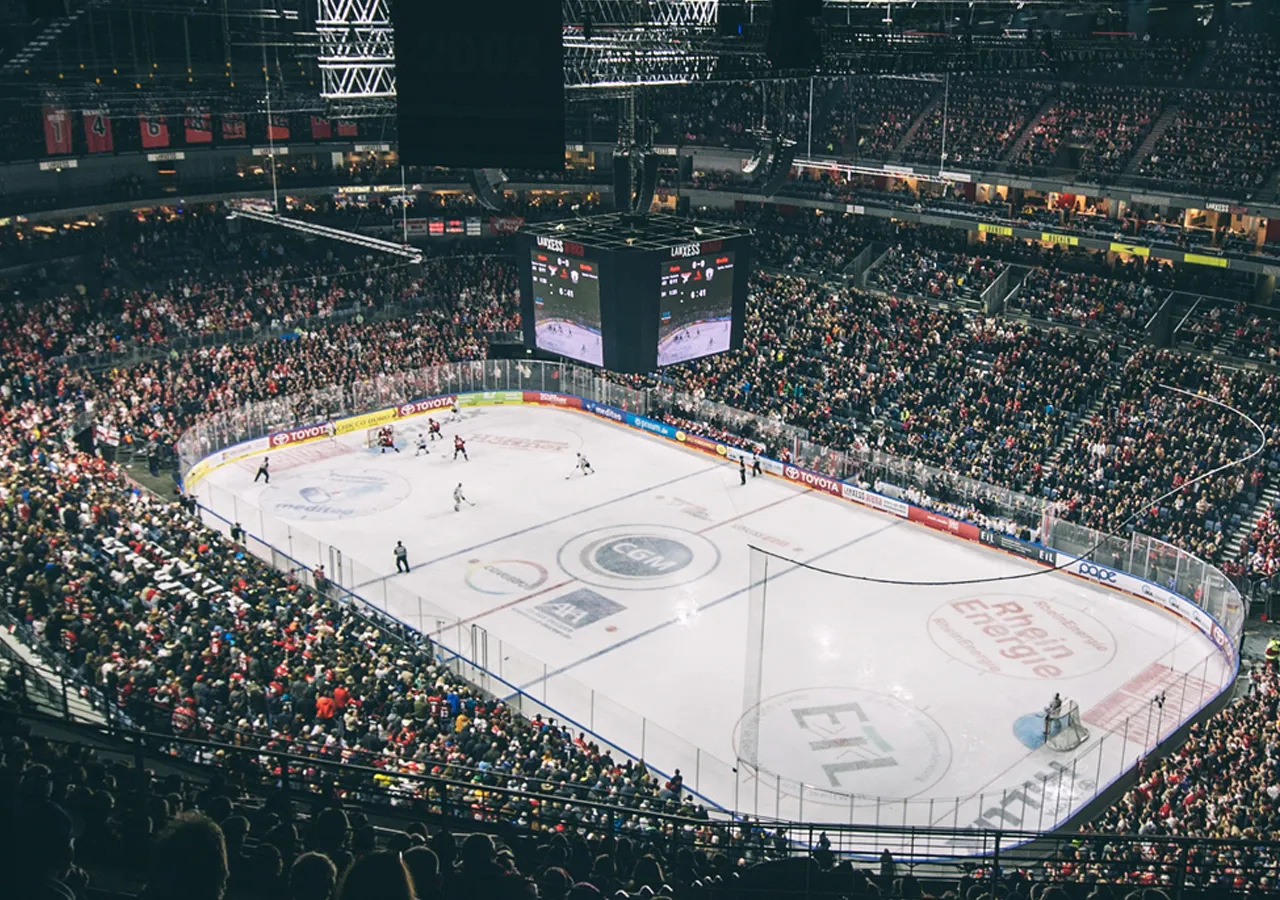 En bred utsikt over en isarena under en hockeykamp med et stort publikum.