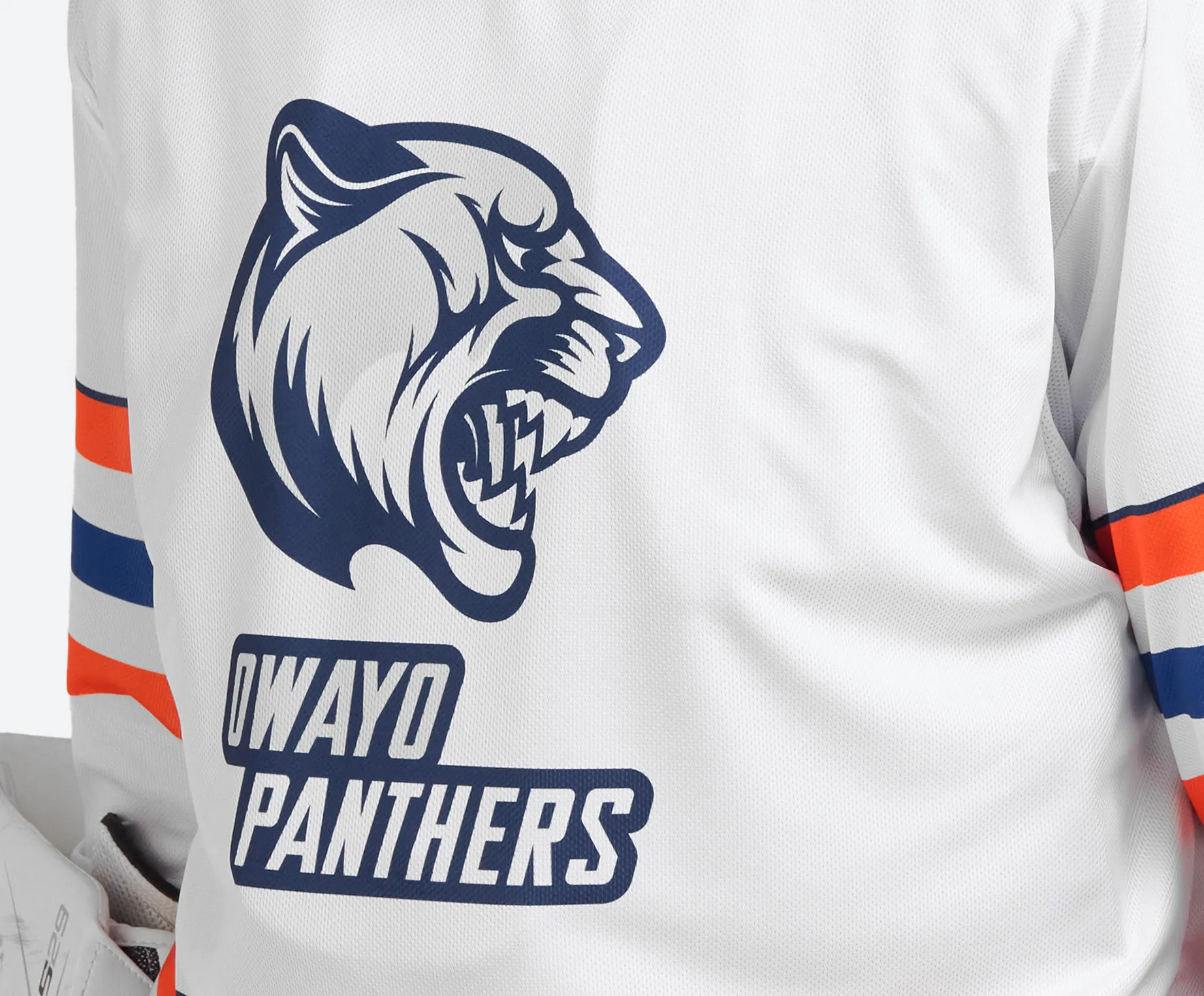 En hvit sportsdrakt med et stort trykt tigerhode og teksten 'owayo PANTHERS' i blå bokstaver på baksiden.