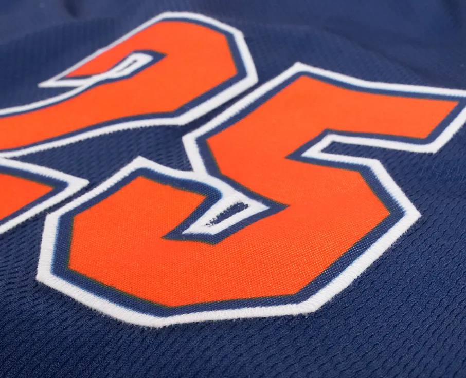 Nærbilde av en blå sportstrøye med nummer 25 i lys oransje.