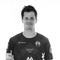 En mann bærer en tilpasset svart-hvitt sportskjorte med geometrisk mønster, owayo-logo, et klubbemblem og teksten 'Euro Winners Cup Nazaré 2022'.