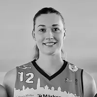 En kvinne i en sportstrøye med nummer 12 og et bysilhuettemønster.