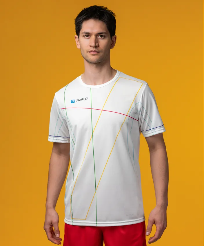 En mannlig modell har på seg en hvit sportskjorte med fargerike linjemønstre mot en gul bakgrunn.
