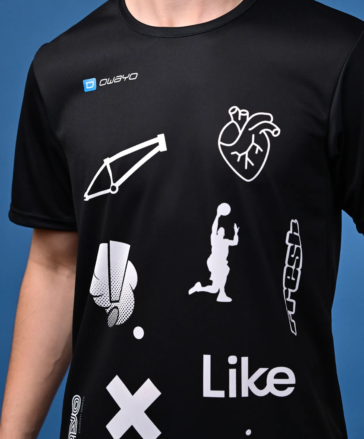 En svart sportskjorte med hvite grafiske design, inkludert symboler for basketball, en hjerterytme og andre sportselementer.