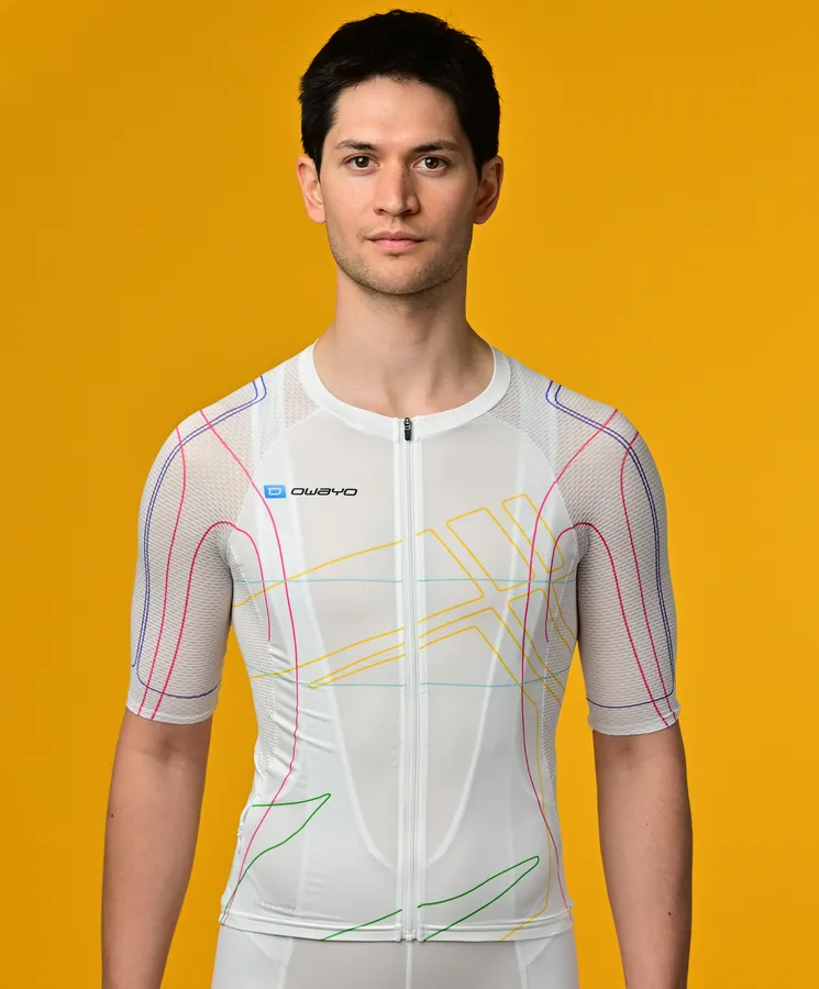 En mann bærer en hvit, kortermet, sporttrøye med fargerike linjer fra owayo foran en gul bakgrunn.