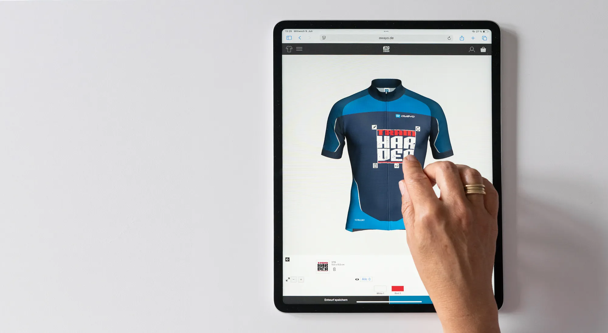 En hånd interagerer med en tablet som viser en tilpasset sykkeltrøye designflate fra owayo, der en blå trøye med et rødt og hvitt design redigeres.