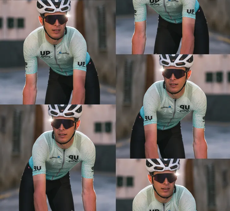 En syklist i en tilpasset lysblå trøye med logoen 'UP cycling' og 'owayo' på brystet, som sykler på en gate.